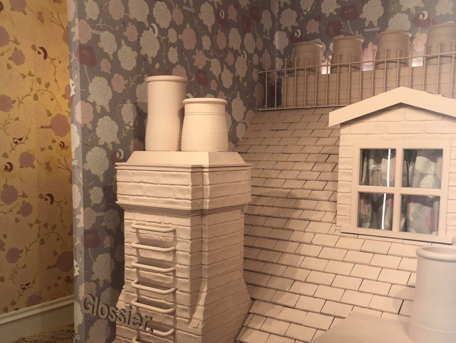 miniature roof in Glossier branded pop-up store